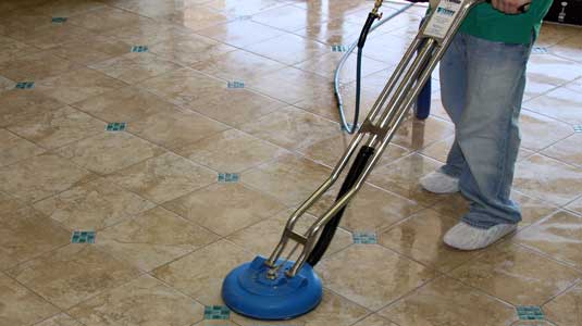 This image shows a man cleaning the tiles using a machine.