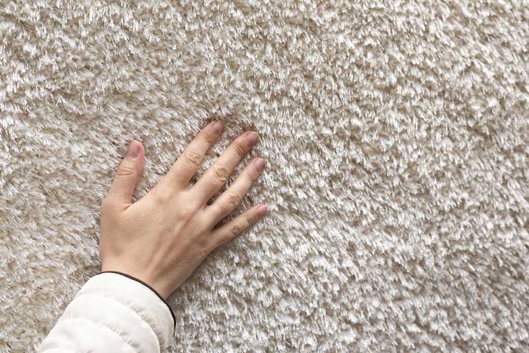 This image shows a hand on a carpet.