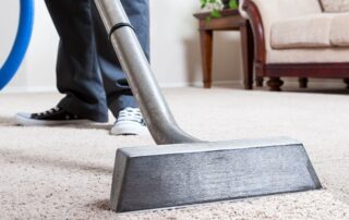 This image shows a vacuum machine being used to clean a carpet.